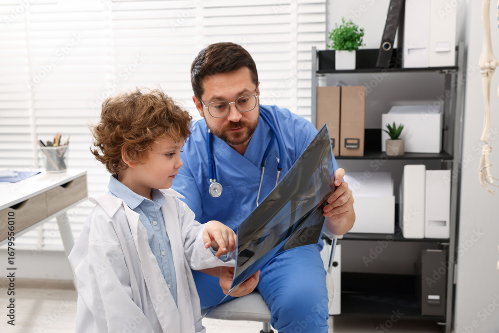 Obraz premium Choice of profession. Father and his son examining X-ray picture in clinic