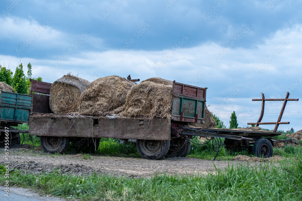 Fototapeta premium Old Farm Trailer Loaded with Hay Bales – Rural Countryside Scene