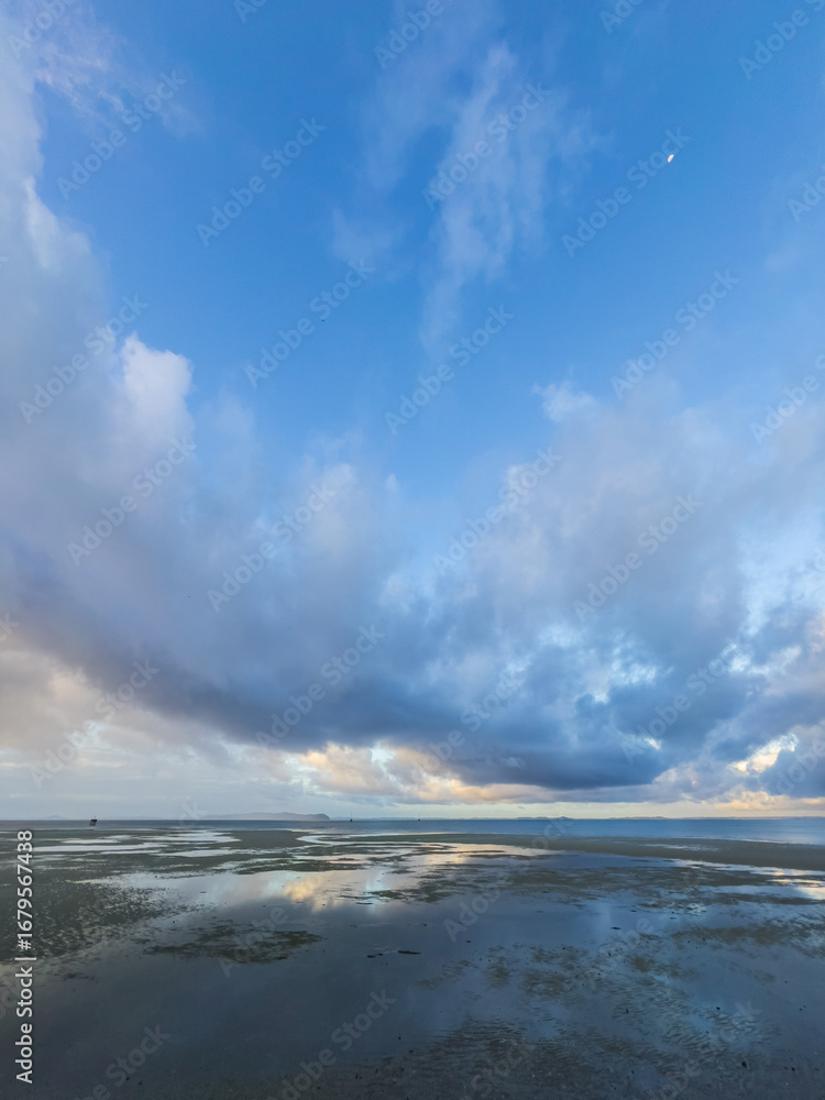 Obraz premium Low Tide Reflections under a Dramatic Cloudy Sky