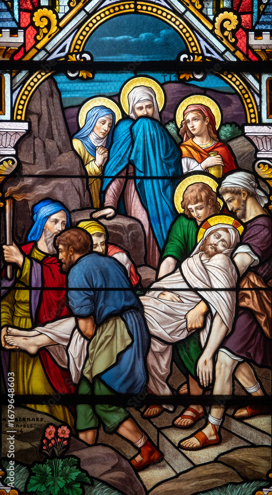 Fototapeta premium Stained glass (1914) of The Way of the Cross. Fourteenth station: Jesus' body is placed in the tomb.