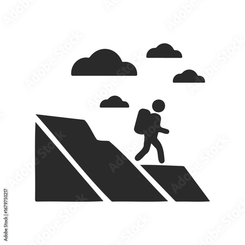 Silhouette of hiker climbing mountain with clouds