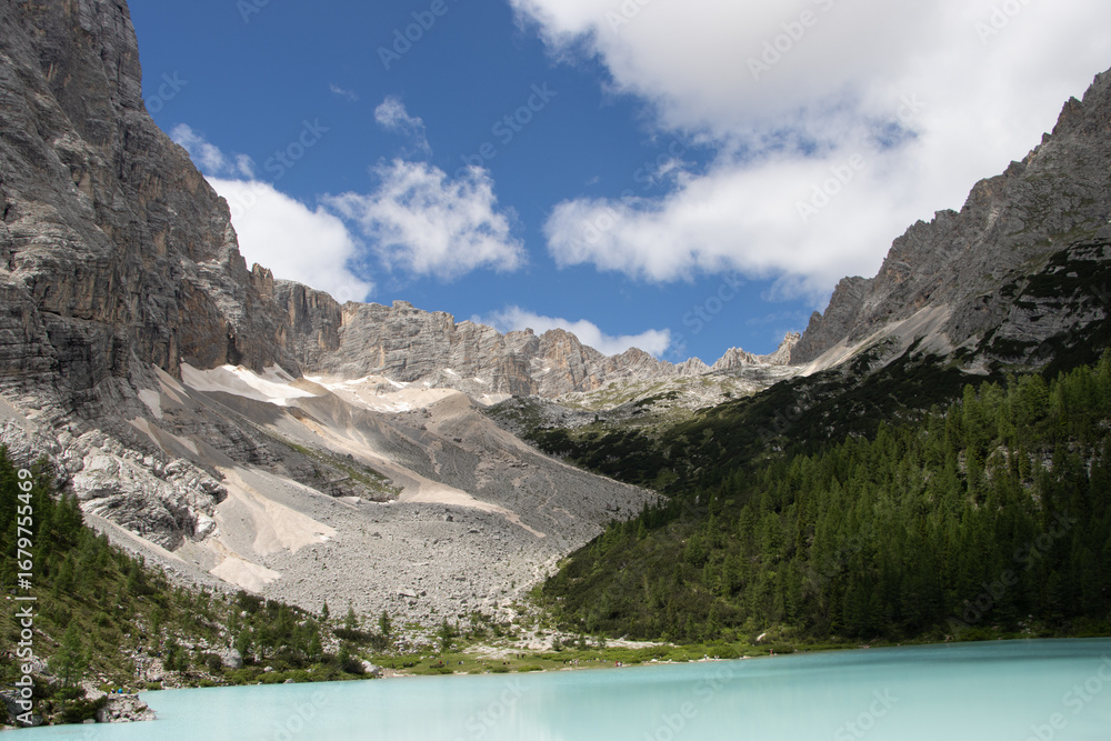 Naklejka premium Photography of Lago di Sorapis, Italy, showing the turquoise glacial lake surrounded by Dolomite mountains, pine forests, and dramatic alpine scenery.