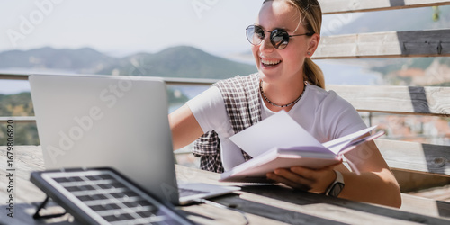 digital nomad woman working remotely from a cozy kitchen during breakfast. Remote work, sustainability, wellness, Gen Z, conscious living, home office and online freelancing