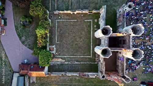 aerial drone shot Birds Eye view moving up over ancient English ruins Titchfield abbey with large crowd in summer at sunset