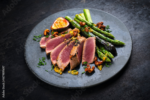 Fotografie Tuna tataki steak with caramelized green asparagus, roasted cashew and  maracuja