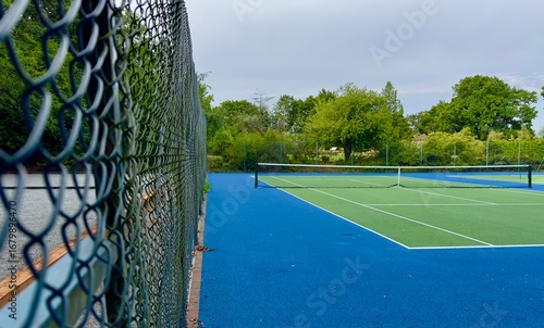A tennis court in an urban park for public use. 
