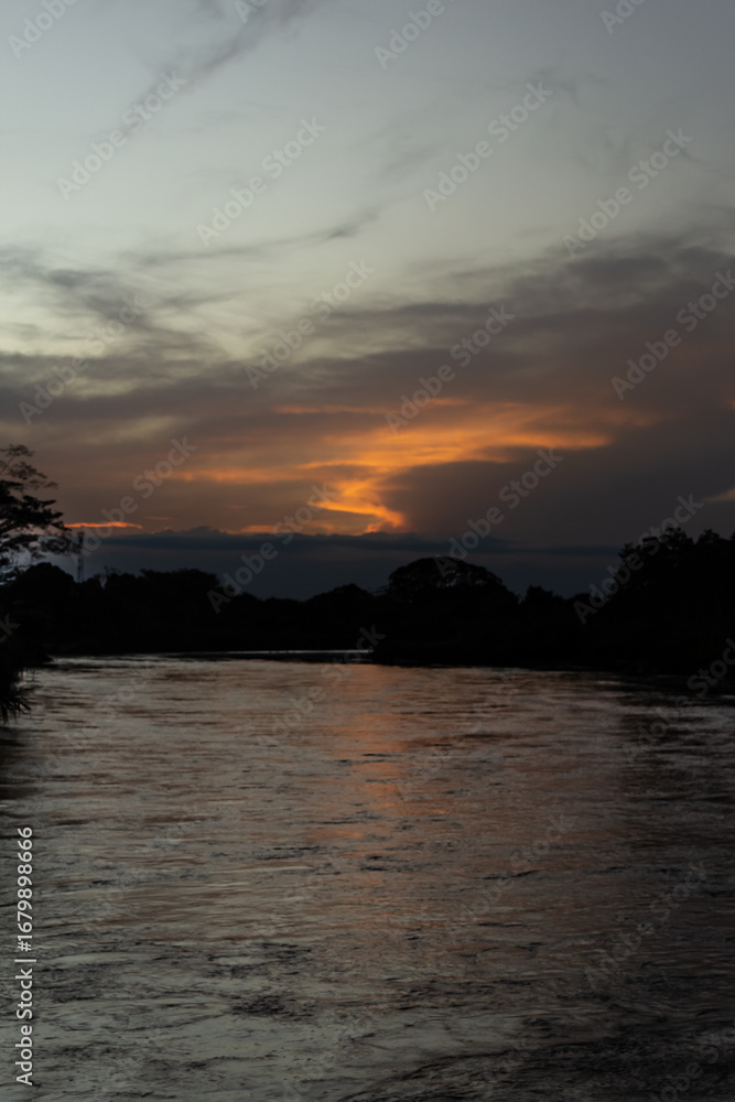 Naklejka premium Sunset on the river in the tropics. Beautiful landscape.