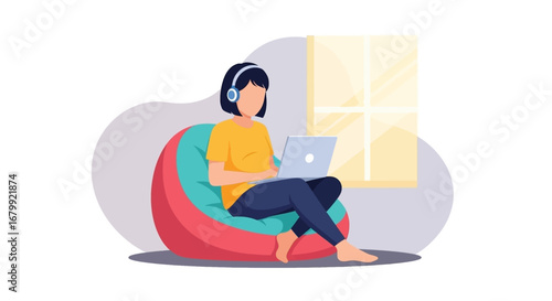 Young woman in headphones comfortably working on laptop while sitting on a bean bag chair at home, by a sunny window. Ideal for remote work, online education, or modern lifestyle.