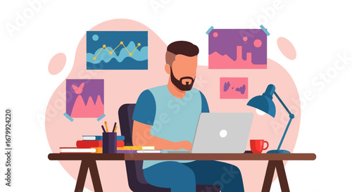 Young man working remotely on his laptop at a home office desk with books and charts, illustrating modern freelance or online education concepts.