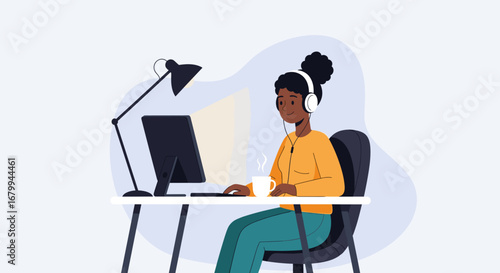 Young black woman with headphones working on a computer at her desk. Ideal for concepts of remote work, online education, or professional productivity.