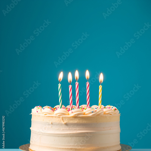 Tasty birthday cake with lighting candles on blue background