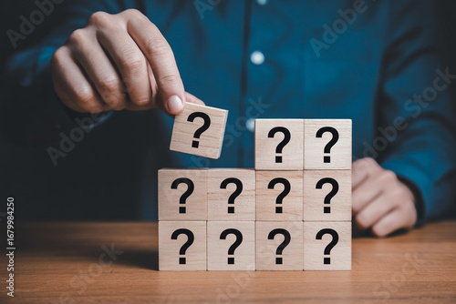 Solving problems and finding answers concept with wooden blocks and question marks symbol puzzle game