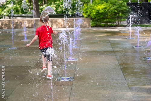 Young boy running through the fountains at the Popup Water Park in St. Louis, Missouri