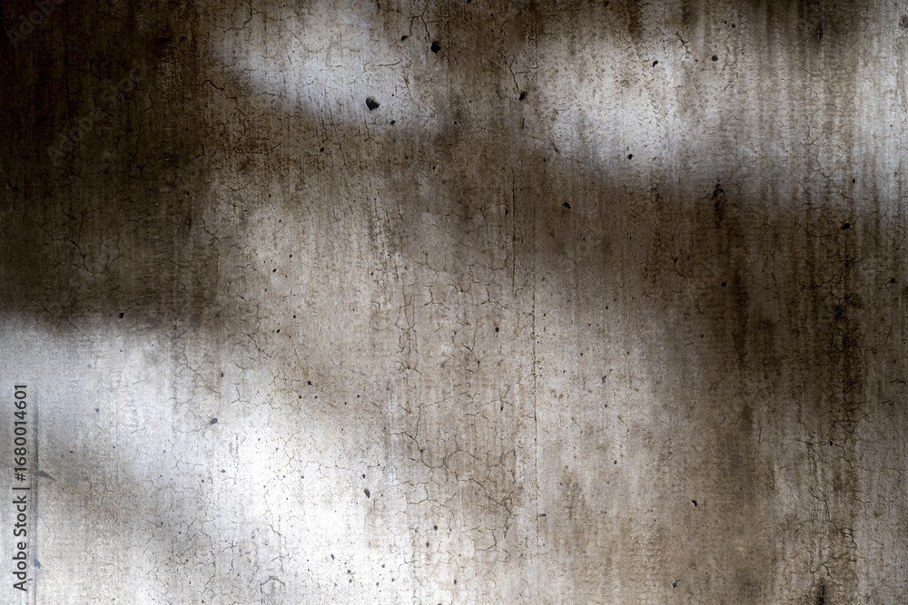 Obraz premium Abstract image of a grungy and aged cement surface. The texture features cracks and a shadow overlay. Copy space. Textured background