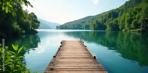 Serene dock extending into calm lake water, surrounded by lush green vegetation  Perfect for relaxation and peaceful waterfront scenes ,  fishing,  waterfront property