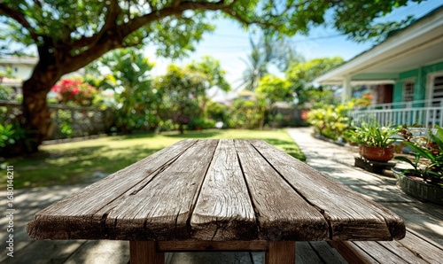Fototapeta Naklejka Na Ścianę i Meble -  Rustic wooden table in a lush, sunny garden