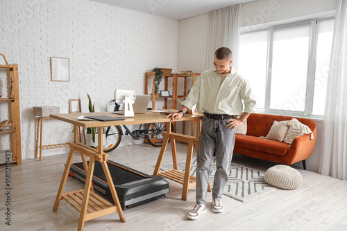 Young man near treadmill un...