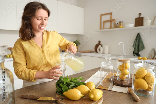 Young woman pouring lemonad...