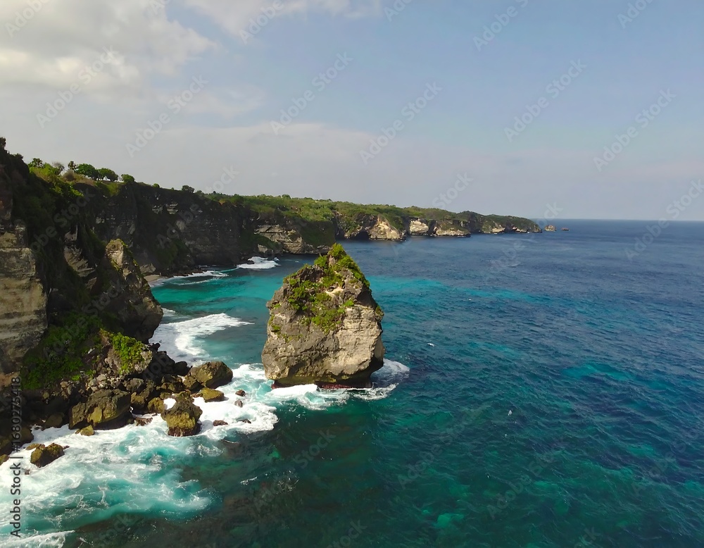 Fototapeta premium Dramatic coastal scene with turquoise waters crashing against dark volcanic rock formations