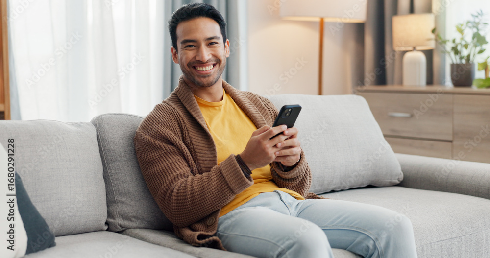 Obraz premium Phone, portrait and smile with man on sofa in living room of home for social media scrolling. App, browsing and communication with happy person typing in apartment for internet search or text message
