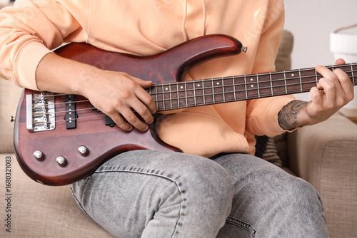 Young man playing electric ...