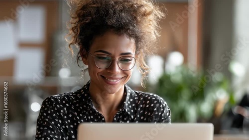 Focused medium shot of a linguist reviewing dialect copy on laptop during a video call with team members and digital notes softly out of focus beyond.