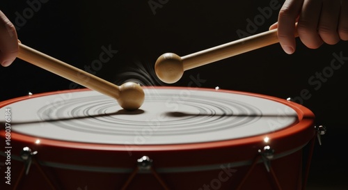 Close-up of drum with wooden sticks hitting it creating motion blur