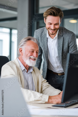 A mentoring session where an older manager coaches a younger employee at a desk