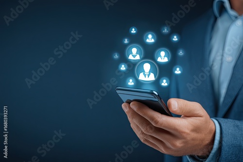 Businessman holds phone, glowing profile icons orbiting