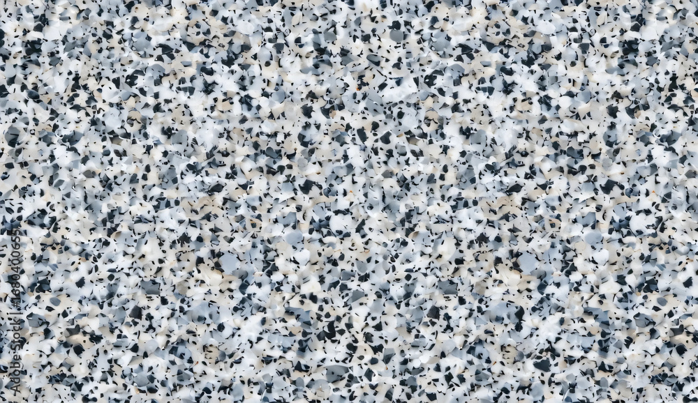 Obraz premium superficie de una losa de granito caracterizada por su patrón moteado. El granito muestra una gama compleja de grises, negros y manchas blancas, creando un aspecto neutro pero texturizado.
