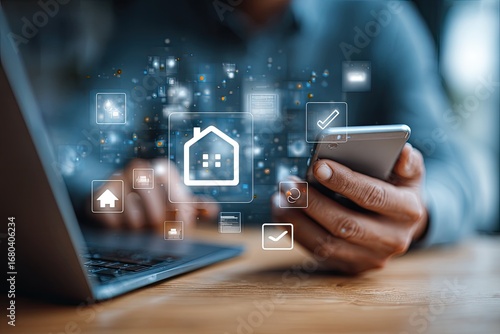 Person using smartphone and laptop for digital home management
