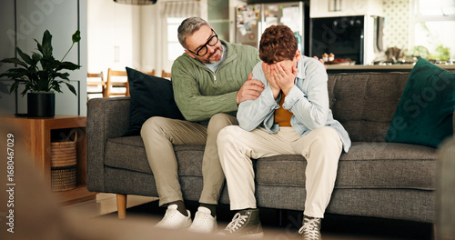 Comfort, consoling and crying son with father on sofa in living room of home for empathy or support. Emotions, love and sad boy child with single parent man in apartment for trust or understanding