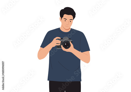 A man with dark hair and a blue shirt is holding a grey camera