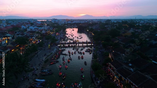 Tourists are enjoying the full moon festival with floating lanterns on thu bon river at sunset in hoi an ancient town, a unesco world heritage site in vietnam