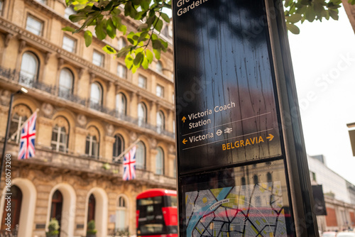 LONDON- Signage for Victoria Coach Station and Victoria railway station and Belgravia in SW1 with British flags in background