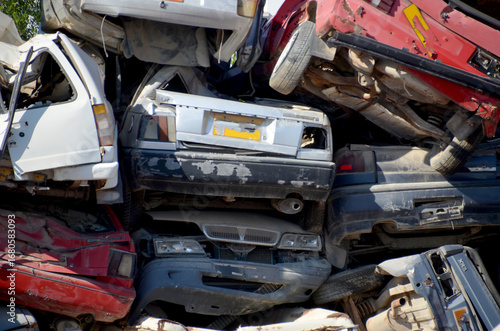 
Stacked old and wrecked cars in a junkyard.

A close-up, horizontal view of a pile of old, crushed, and wrecked cars, showing a mix of different colors and models at a scrapyard.