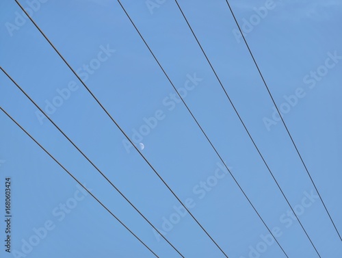 Wallpaper Mural A view of power lines against a clear blue sky with a small moon Torontodigital.ca