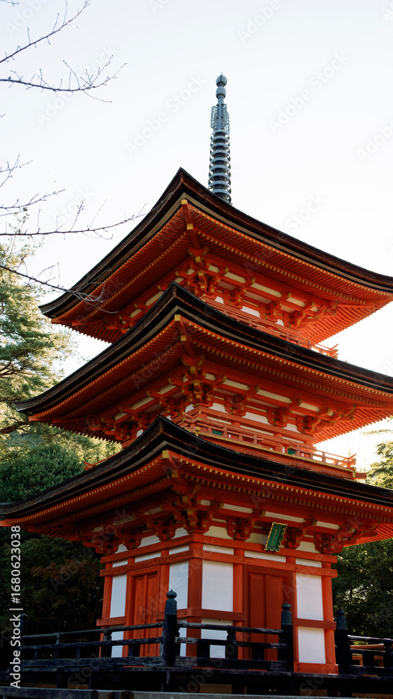 Naklejka premium Majestic three storied pagoda standing tall in japanese garden
