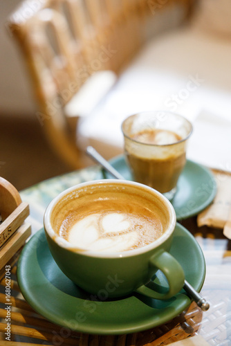 Cup of hot milk latte coffee and piccolo latte coffee on table by the window.
