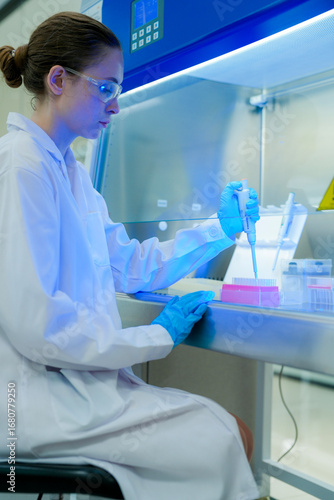 Cuadro en lienzo A scientist carefully uses a micropipette to transfer a liquid sample inside a biosafety cabinet