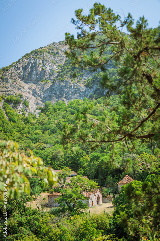 Fototapeta premium Ancient Armazi Monastery hidden in lush green forest near Mtskheta, Georgia. Peaceful spiritual retreat nestled in nature. Ideal for travel, history, editorial, and religious tourism themes
