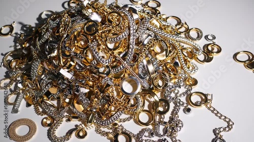 Accumulation of precious metal discards and argentum costume adornments isolated on plain white surface