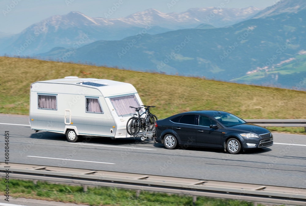Naklejka premium Family Car With RV Van And Bicycles in Mountainous Scenic Landscape