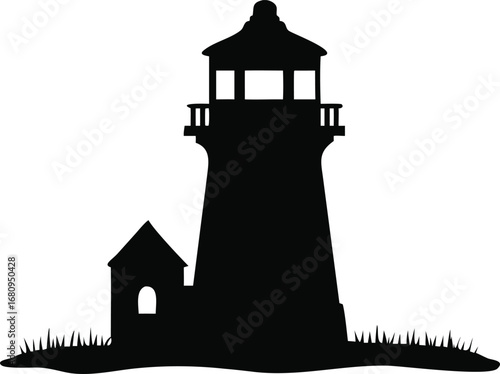 Classic tall silhouette lighthouse guiding ships safely across the sea at dusk with coastal grass below silhouette