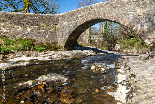 west burton village in the yorkshire dales national park north yorkshire england and the stone bridge over the walden beck blue sky no people