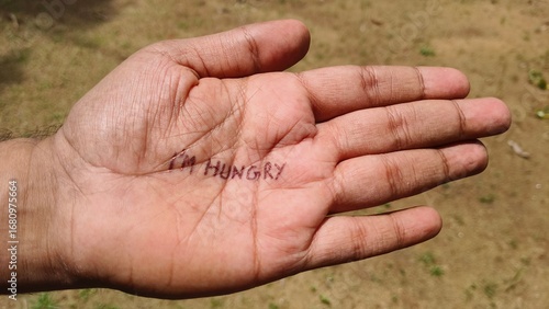 Vászonkép I'm hungry word or text written on starving poor refugee or homeless adult person palm