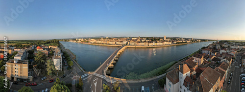 Vue aérienne panoramique de la ville de Mâcon avec un premier plan le pont Saint-Laurent franchissant la Saône et débouchant sur le quai Lamartine