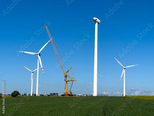 Wind turbines under maintenance. A crane operationg on removed blades.