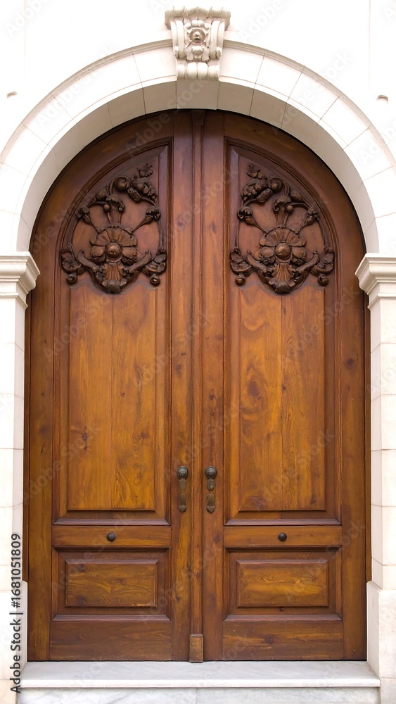Fototapeta premium Ornate wooden double doors in an arched doorway