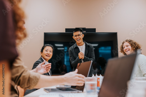 Happy young male business professional enjoying with colleague in office meeting room